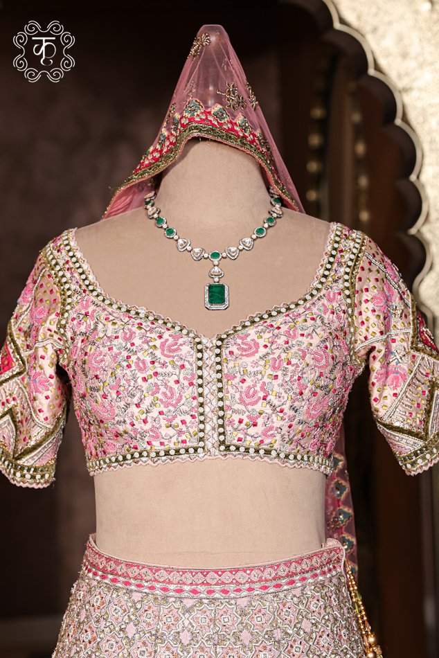 Close-up of the hand-embroidered sweetheart neckline blouse with chevron sleeve details from the Hand Embroidered Heavy Bridal Lehenga Choli Set.