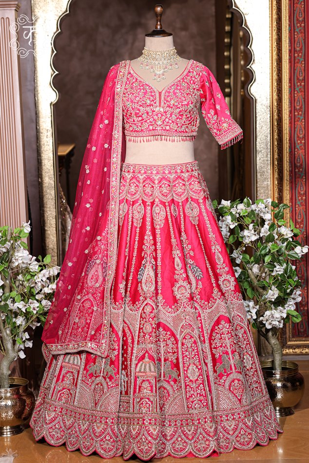 Hand Embroidered Heavy Bridal Lehenga Choli Set featuring an intricately embellished sweetheart-neck choli, a flared palace-motif lehenga skirt with a scalloped hem, and a matching net dupatta from Kridhaa.