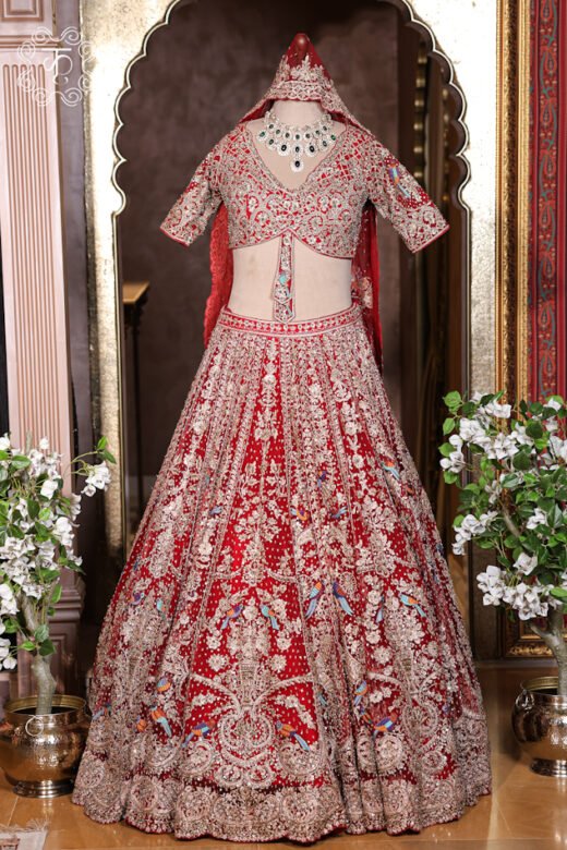 Hand Embroidered Heavy Bridal Lehenga Choli Set featuring an intricately embellished V-neck choli, a flared skirt with bird motif zardozi embroidery, and a matching net dupatta from Kridhaa.