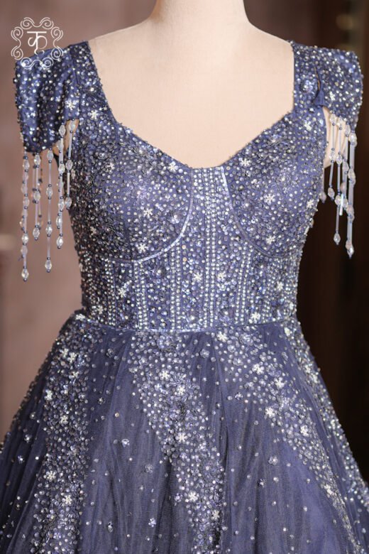 Detailed view of the cascading silver crystal swirl motifs and sequin spray on the skirt of the Crystal Sequined Sweetheart Corset Ball Gown.