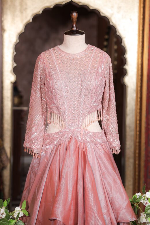 Cut-Out Waist Hand-Embroidered Organza Tiered Ruffle Gown featuring a jeweled embroidered bodice, side cut-outs with crystal tassels, and a tiered ruffle skirt from Kridhaa.