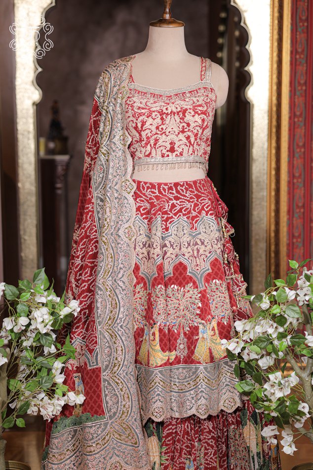 Close-up of the Pichwai dancing figure prints, architectural jharokhas, and scalloped embroidered tier borders on the Printed Silk Lehenga Set skirt.