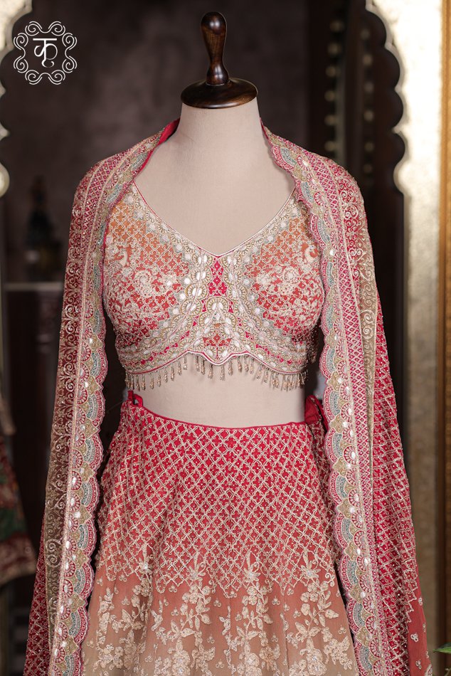 Close-up of the scalloped sweetheart neck, mirror-work zardozi embroidery, and hanging bead tassels on the choli of the Ombre Georgette Lehenga Set.