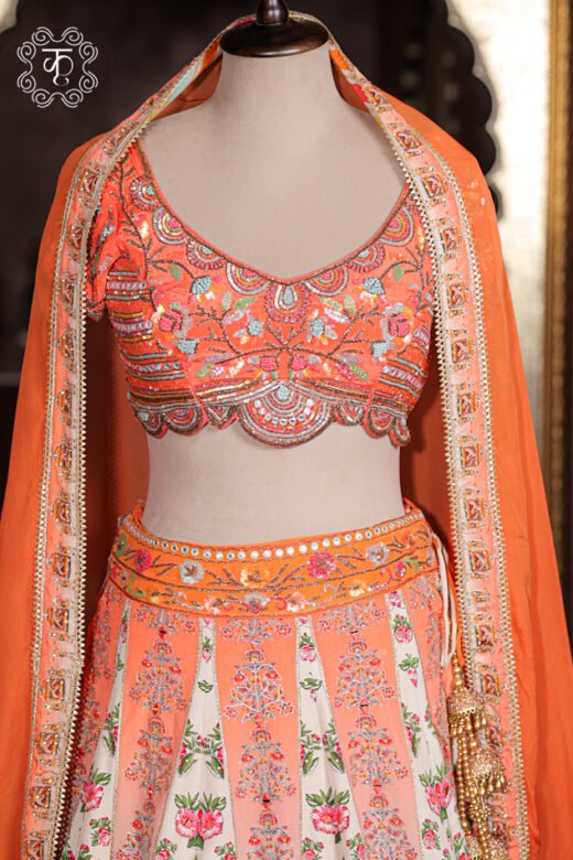 Close-up of the scalloped hem, multi-color thread embroidery, and mirror work on the choli of the Printed Silk Lehenga Set.