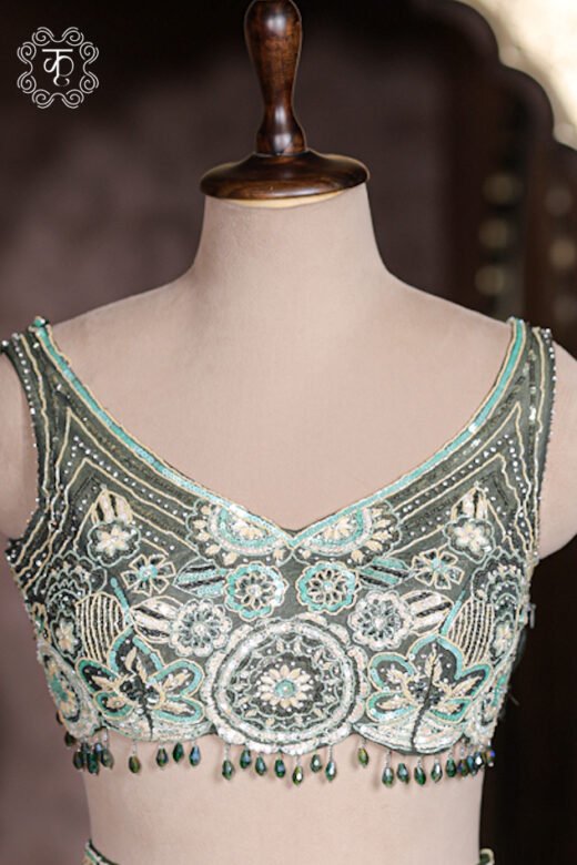 Dark green net dupatta draped with silver sequin spray matching green silk lehenga.