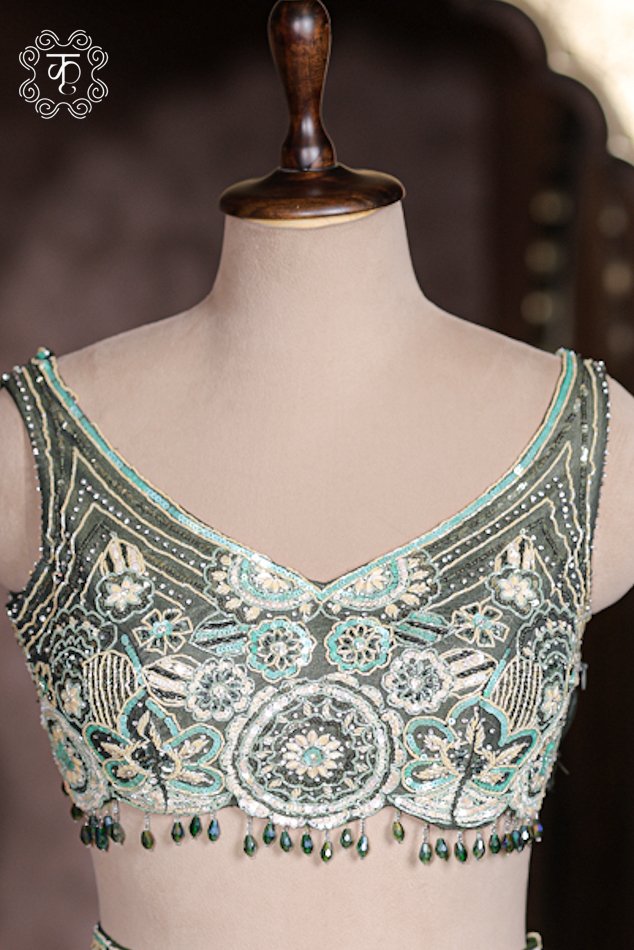 Dark green net dupatta draped with silver sequin spray matching green silk lehenga.