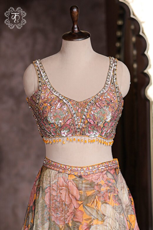 Close up of mustard yellow sleeveless sweetheart blouse with mirror work, sequins, and hanging bead fringe.