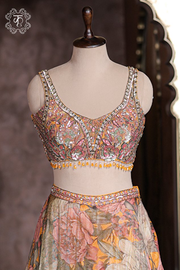 Close up of mustard yellow sleeveless sweetheart blouse with mirror work, sequins, and hanging bead fringe.
