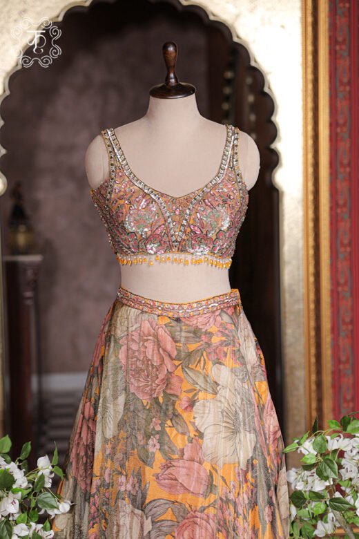 Sheer mustard yellow net dupatta with sequin spray and printed silk border draped on shoulder.