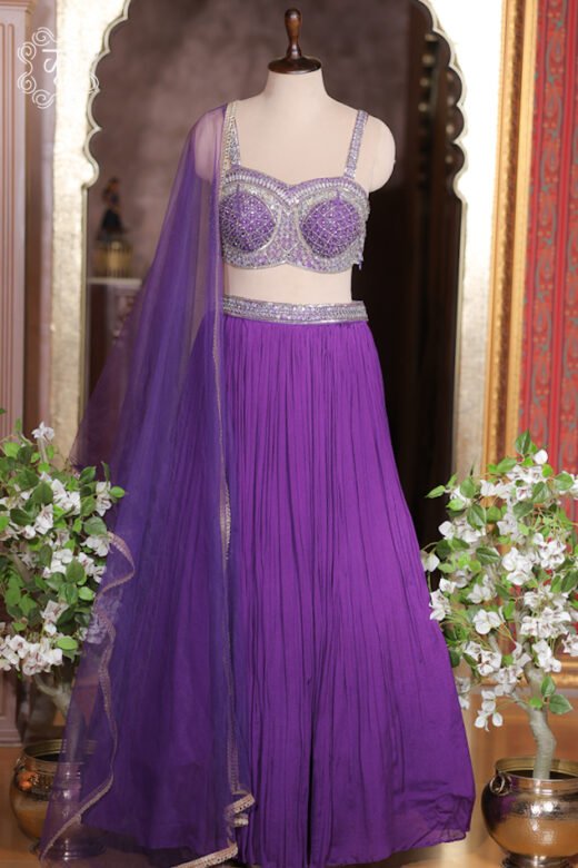 Close up of royal purple georgette lehenga waistband with heavily embroidered silver mirror border.