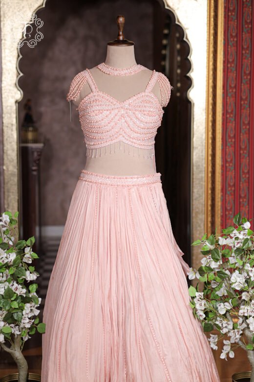 Blush pink pearl embroidered corset lehenga set with vertical pearl stripes on pleated skirt.