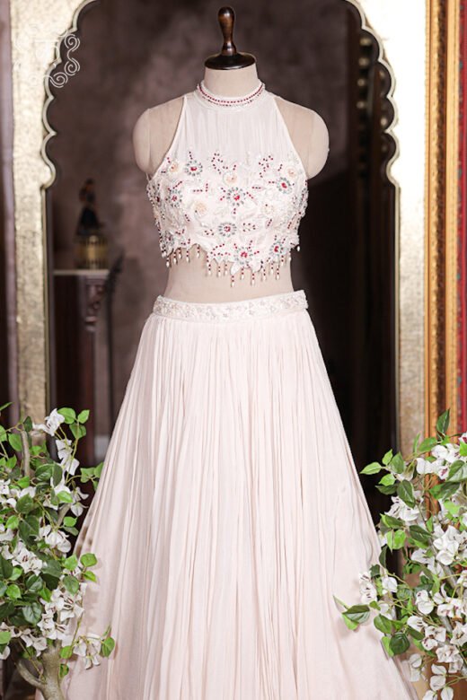 Scalloped hem of embroidered choli top featuring delicate dangling pearl and crystal fringes.