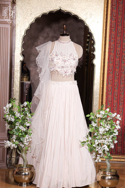 Side profile view of flared blush pink pleated lehenga skirt showing graceful drape and movement.