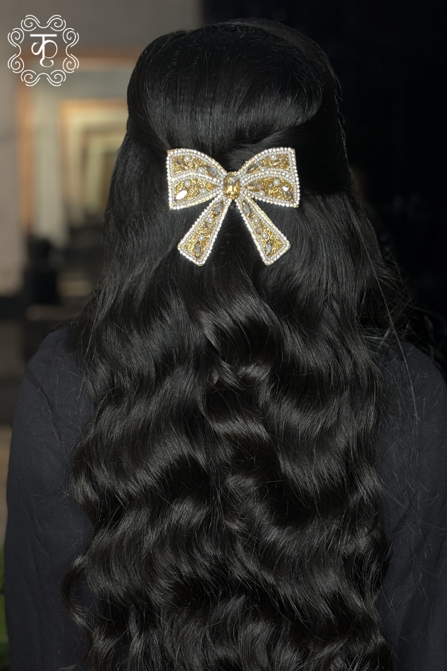 Gold and pearl embellished bow hair clip styled on wavy hair — Kridhaa Hair Accessories collection