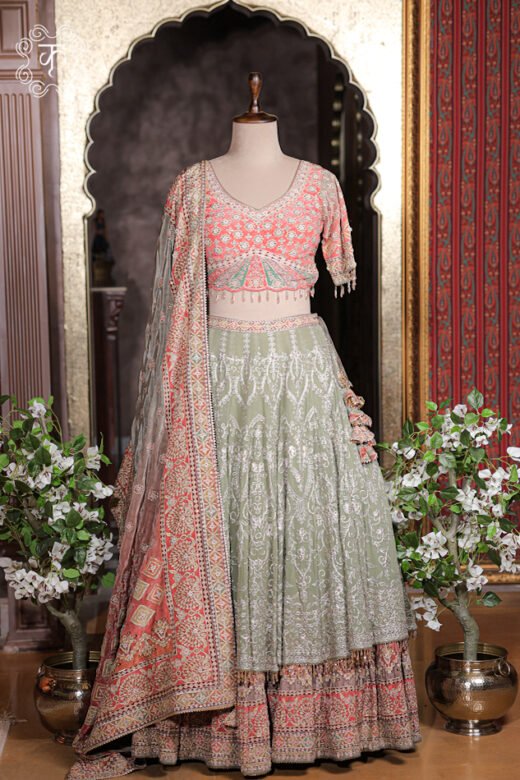 Sage green and peach pink layered silk lehenga set with embroidered V-neck blouse and heavy dupatta.