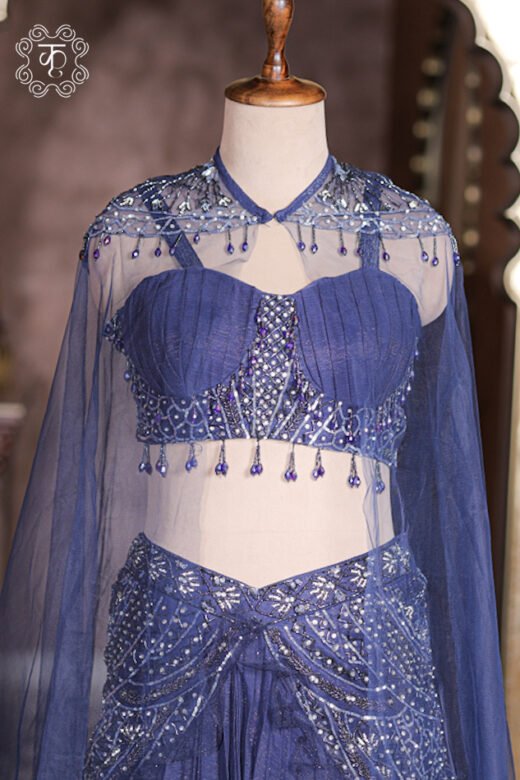 Navy blue metallic crush pleated georgette lehenga set with sheer net cape and embroidered waist yoke.