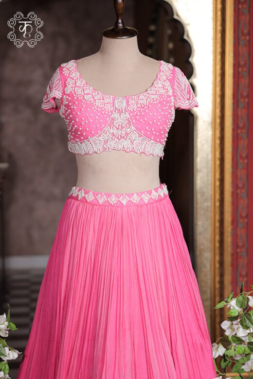 Bubblegum pink crush pleated georgette lehenga set with white pearl embroidered blouse and sheer ruffled cape.