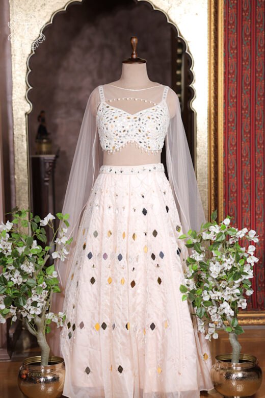 Ivory white mirror work organza lehenga set with heavily embroidered bustier and sheer floor length cape.
