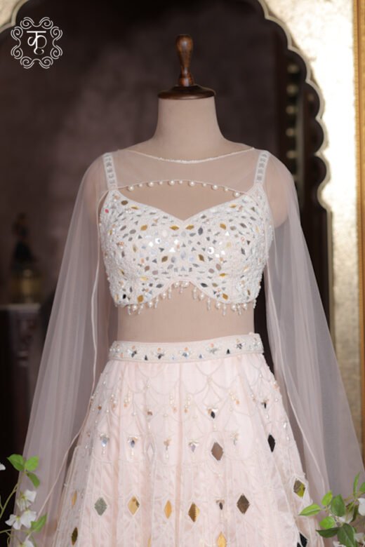 Organza fabric detail of ivory lehenga skirt showing geometric diamond mirrors and pearl threads