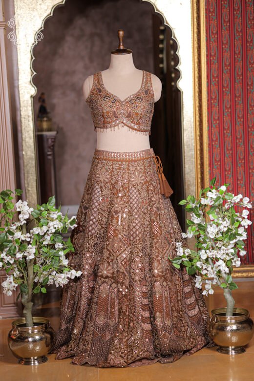 Close up of rust bronze sweetheart neck blouse with paisley embroidery, sequins, and dangling bead fringe hem.