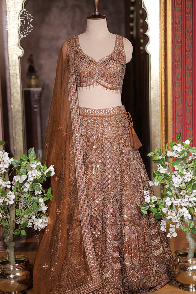 Sheer rust bronze net dupatta with sequin-embroidered border trim draped neatly over shoulder.