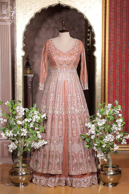 Close up of rust orange V-neck bodice with dense silver zardozi and floral thread embroidery.