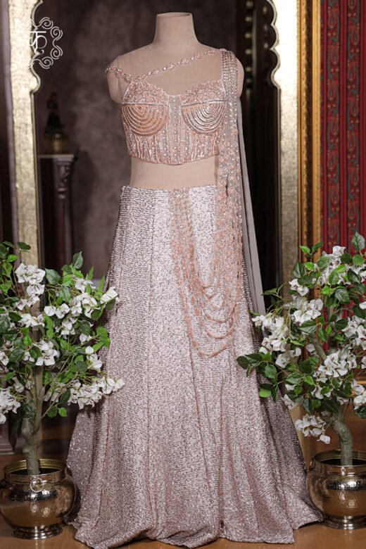 Detailed texture of blush pink lehenga skirt showing all-over textured metallic sequin embroidery.